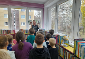 Pani bibliotekarka pokazuje dzieciom książki.