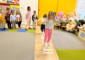 Dziewczynka skacze po planszy.