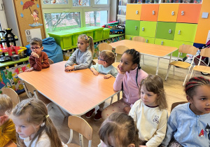 Dzieci siedzą przy stoliku.