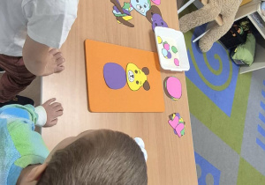 Dzieci układają misia.