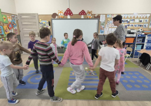 Dzieci tańczą w kółeczku.