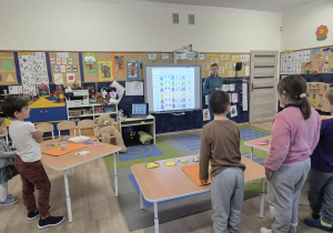 Dzieci słuchają poleceń nauczycielki.