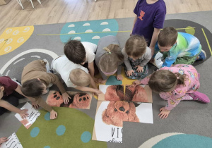 Dzieci układają misiowe puzzle.