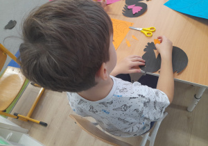 Chłopiec tworzy swojego łowickiego kogutka.