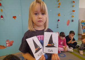 Dziewczynka prezentuje wylosowane ilustracje.