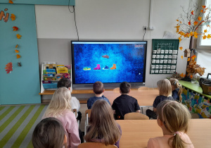 Dzieci oglądaja film edukacyjny o Andrzejkach.