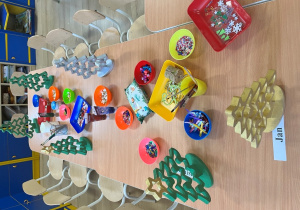 Stoliki z materiałami do dekoracji choinek.