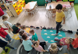 Dzieci układają buty jeden za drugim.