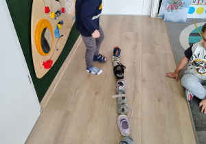 Dzieci układają buty jeden za drugim.