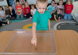 Chłopiec rzuca monetą.