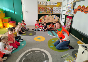 Dzieci siedzą na dywanie.