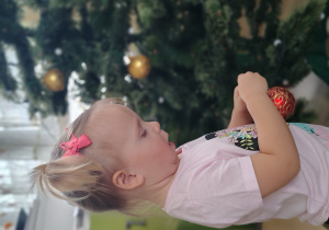 Dziewczynka ubiera choinkę.