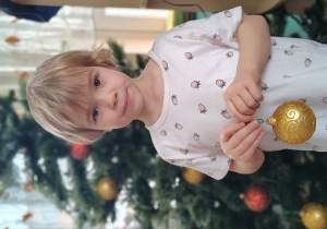 Dziewczynka ubiera choinkę.