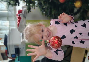 Dziewczynka ubiera choinkę.