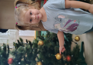 Dziewczynka ubiera choinkę.