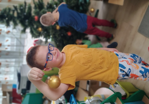 Chłopiec ubiera choinkę.