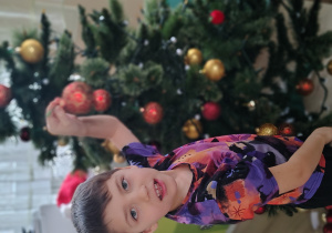 Chłopiec ubiera choinkę.