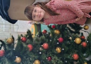 Dziewczynka ubiera choinkę.