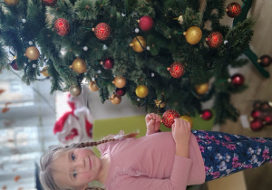 Dziewczynka ubiera choinkę.