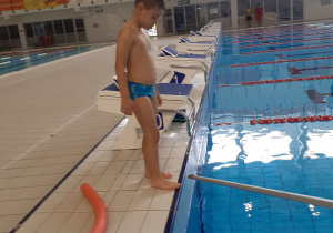 Dziecko stoi przy basenie