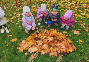 Dzieci układali kopiec liści.