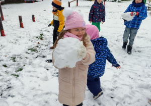 Dziewczynka lepi kulę.