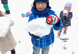 Chłopiec lepi kulę.