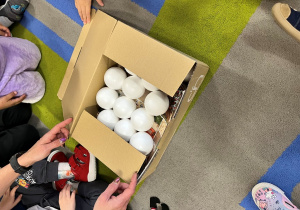 Dzieci rozpakowują pudełko.