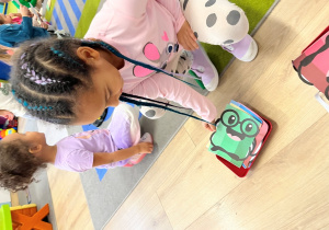 Dziewczynka wybiera z pudełka obrazek.