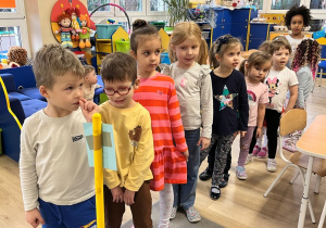 Dzieci ustawione w szeregu czekają na wykonaie zadania.