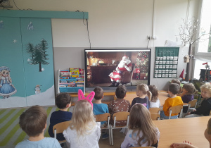 Dzieci oglądają film od Św. Mikołaja.
