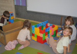 Dzieci budują rakietę z klocków.