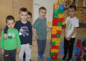 Dzieci budują rakietę z klocków.