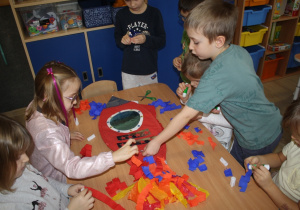 Dzieci tworzą rakietę z bibuły.