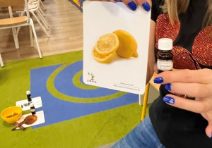 Ilustracja cytryny i buteleczka z olejkiem.