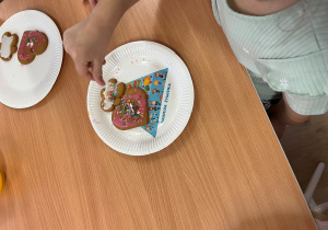 Dziecko dekoruje pierniczek.