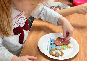 Dziecko dekoruje pierniczek.