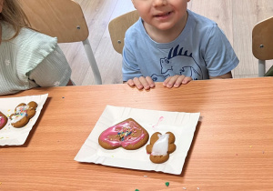 Dziecko dekoruje pierniczek.