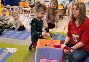 Dziewczynka wyjmuje z pudełka zagadkę od Teo.