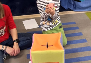 Chłopiec wyjmuje z pudełka zagadkę od Teo.