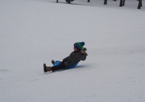 Chłopiec zjeżdża z górki.