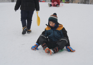 Chłopiec zjeżdżają z górki.