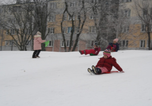 Dziewczynka zjeżdża z górki.