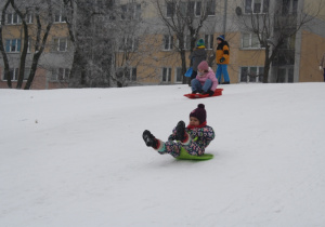 Dziewczynka zjeżdża z górki.