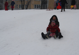 Dzieci zjeżdżają z górki.