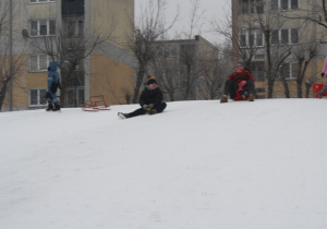 Dzieci zjeżdżają z górki.