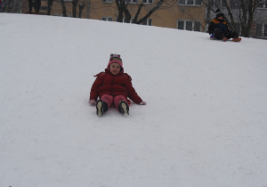 Dzieci zjeżdżają z górki.