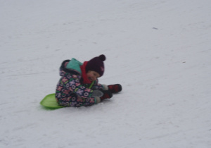 Dzieci zjeżdżają z górki.