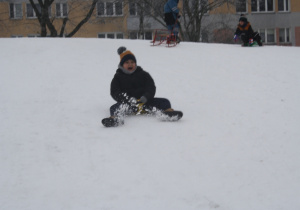 Dzieci zjeżdżają z górki.