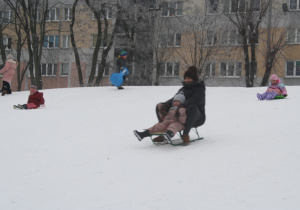 Dzieci zjeżdżają z górki.